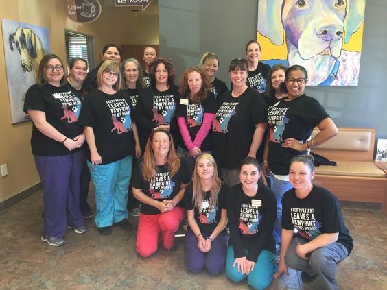 A whole clinic team wearing matching Every Patient Leaves a Pawprint tees