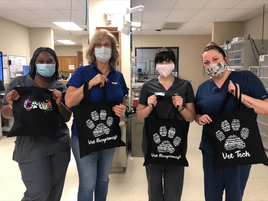 Four clinic staff holding their personalized tote bags