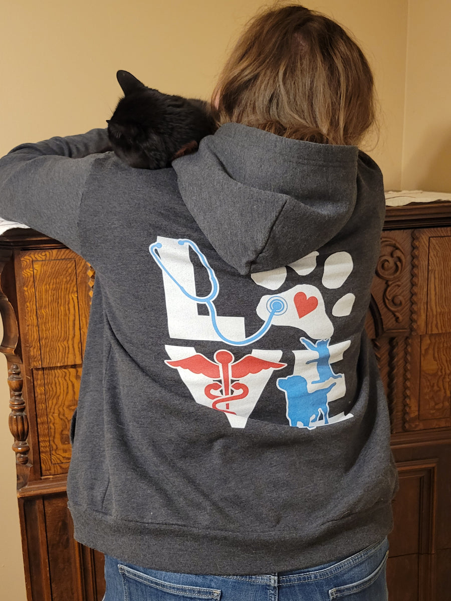 A customer wearing the LOVE zip hoodie with a cat on her shoulder
